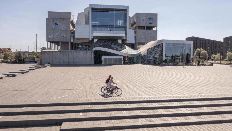 syklister passerer musikkens hus i Aalborg, Danmark