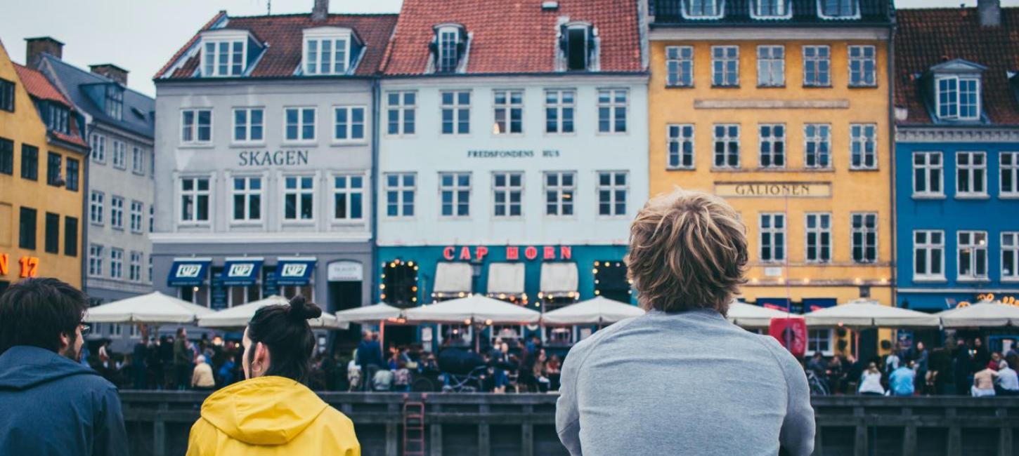 People sitting by the dock in Nyhavn, Copenhagen