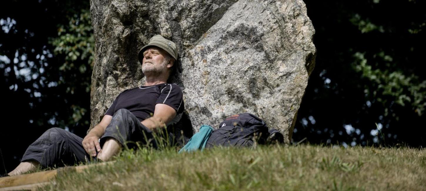 Wanderer macht Rast am Denkmal Skibelund Krat auf dem dänischen Pilgerweg Heerweg