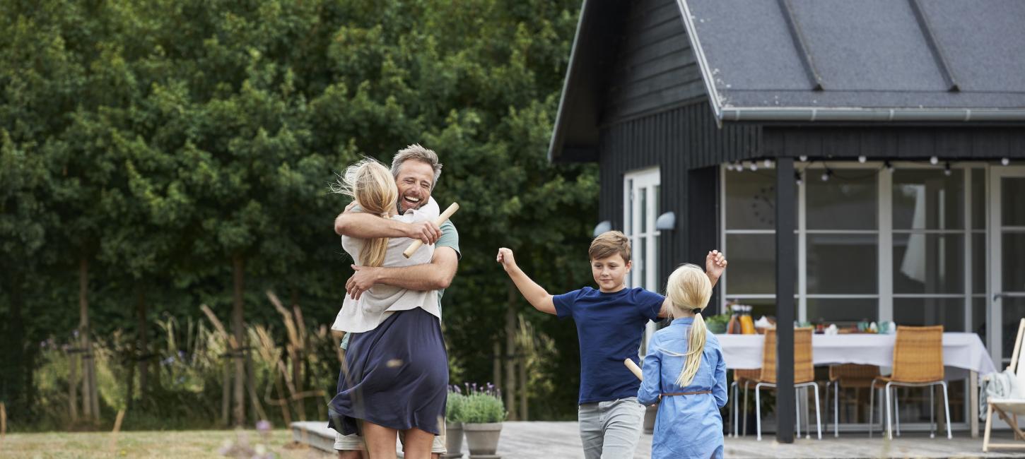 Famile som klemmer utenfor et feriehus i Danmark