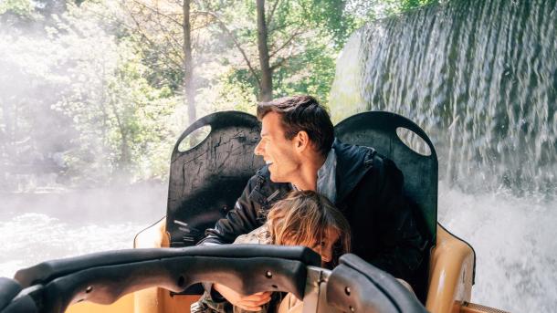 Far og sønn kjører en karusell på Fårup sommerland