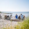 Een familie rust tijdens een fietsvakantie uit op het strand in Sønderjylland