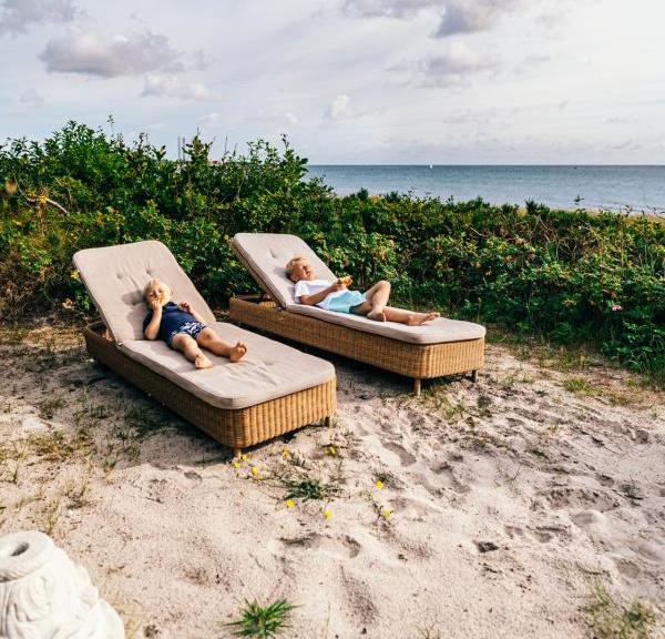 To gutter på loungestoler på Grenaa Strand i Djursland, Danmark