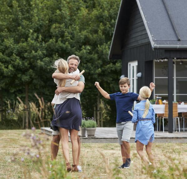 Famile som klemmer utenfor et feriehus i Danmark