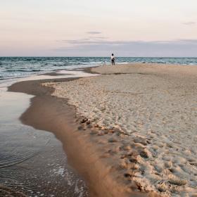 Kvinne som står på stranden på Grenen i Skagen i Danmark