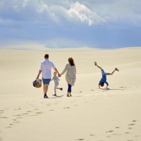 En familie som går gjennom Råbjerg Mile i Nordjylland