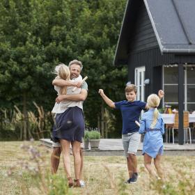 Famile som klemmer utenfor et feriehus i Danmark