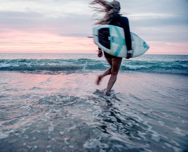 Surfer på stranden i Klitmøller Cold Hawaii på nordvestkysten av Danmark