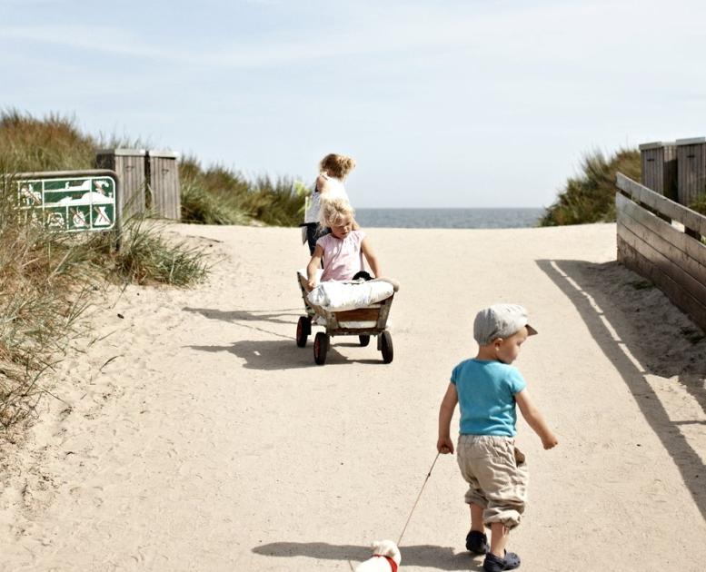 3 barn på vei til stranden i Marielyst, i Danmark